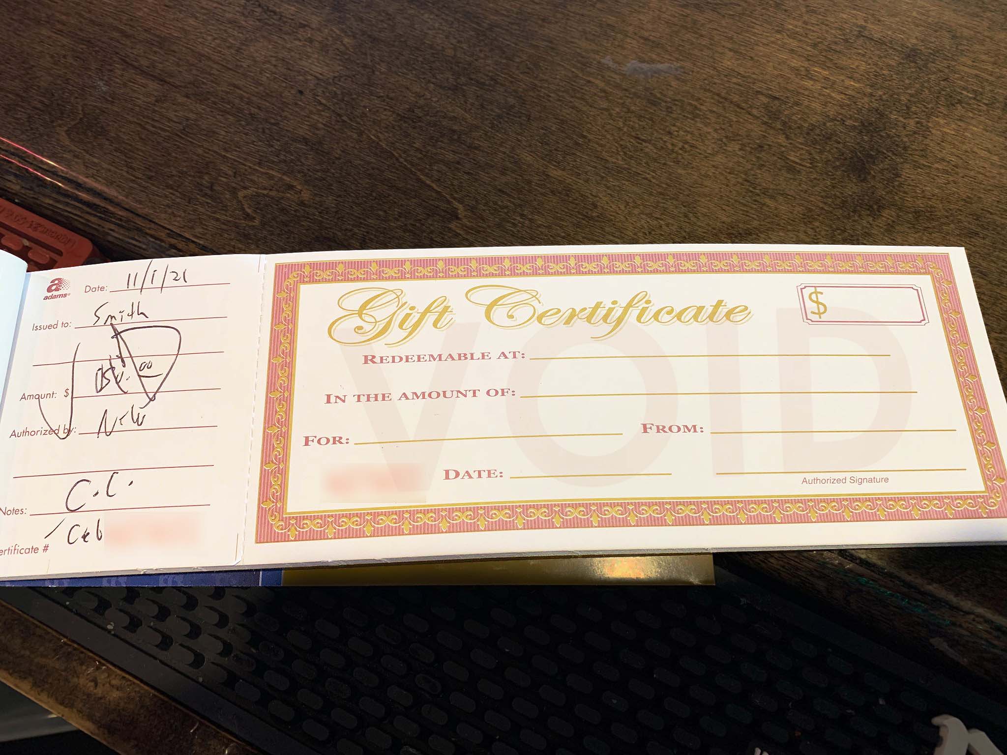 Mexican Cantina restaurant gift certificate booklet displayed on a wooden counter in Staten Island.